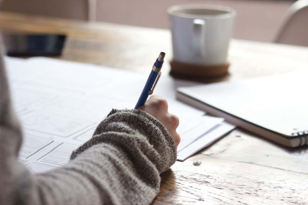 woman writing her business thoughts down on paper